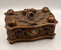 Top and front view of molded composition jewellery casket showing floral relief and lock plate with key