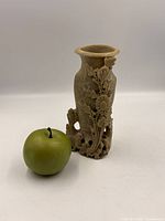 Front view of soapstone vase beside apple for scale
