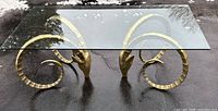 Full view of glass top table with both brass rams head bases visible
