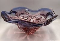 Angled side view showing wavy rim and layered purple-pink glass