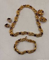 Full set laid out: necklace, bracelet, two earring pairs