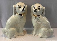 front view of both Sadler Burslem spaniel figurines showing glaze, gilt accents, and collars
