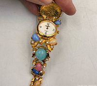 Dial and open cover showing watch face and decorative stones