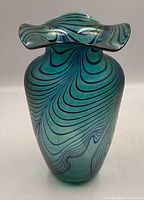 Front view of teal iridescent Robert Held vase with swirl pattern