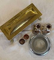 All items overview: brass box closed, two candlesticks, wine coaster, two wine collars