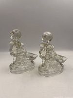 Two clear glass Goose Girl bookends, side profile