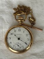 Front view of Waltham pocket watch with chain and fob
