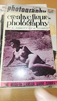 Cover of 'Creative Figure Photography' with partial view of other books beneath