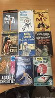 Nine Agatha Christie pocket books laid out in three rows