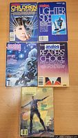 Five Analog magazines/anthologies on table showing cover art including Children of the Future and Lighter Side