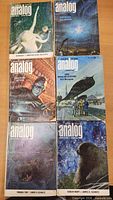 Six Analog magazines laid out showing front covers with alien octopus, space station, astronaut, etc.