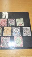 Eight King Edward VII stamps on black stock sheet, various colours and cancels visible