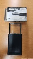 Magnifier extended showing rectangular lens and original box