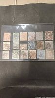 Front view of all 18 stamps in plastic sleeve