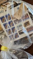 Bag containing numerous clipped stamps, visible Canada blue Queen Elizabeth II 5¢ issues