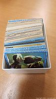 Stack of trading cards in plastic card box showing E.T. card on top