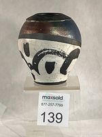 Front view of Algis Bubnys raku vase showing wax-resist design and metallic glaze band
