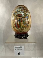 Full view of porcelain egg on wooden stand