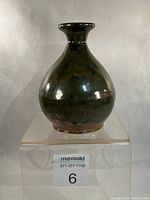 Front view of mottled green-brown stoneware tiger whiskey jug