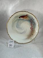 Front view of plate on stand showing full artwork and gold rim