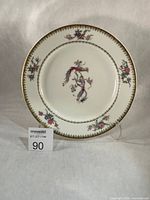 Front view of porcelain plate showing Bird of Paradise pattern and gilt rim