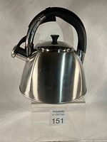 Front-left view of stainless steel whistling kettle showing body, handle, lid and spout