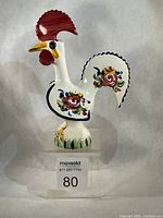 left profile of ceramic rooster on acrylic stand