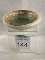 Full view of porcelain shell bowl on stand showing exterior shell texture and interior glaze