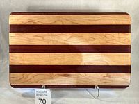 Full front view of striped maple, walnut, mahogany cutting board on stand
