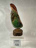 Front view of painted driftwood sculpture on wood slice base showing nature scene and label 58
