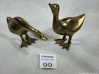 Both brass duck figurines front view with sizing card
