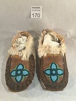 Full view of both moccasins showing beadwork and fur trim