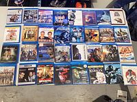Full tabletop view of 30 Blu-ray cases laid out in five rows