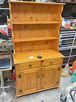 Front view of pine hutch cabinet showing shelves, drawers, cupboard doors