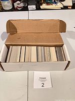 Closed white cardboard box with football cards visible from top