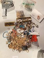 Overall lot with jewelry pile, tagging gun, findings bag and compartment box