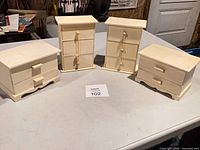 Four unfinished wood jewelry boxes on table