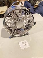 Front view of stainless steel table fan showing grille and blades