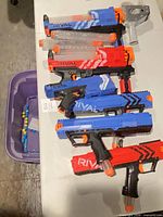 Six Nerf Rival blasters arranged on table with magazines and stock