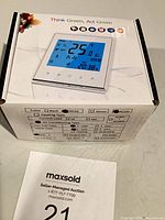 Boxed thermostat with product image and MaxSold sheet visible
