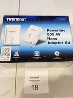 Front of sealed box showing product name, image of the two adapters, speed rating and key features