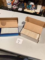 Two open cardboard boxes filled with hockey cards