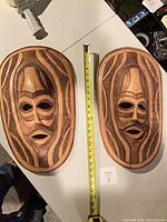 Both masks side by side with measuring tape showing height