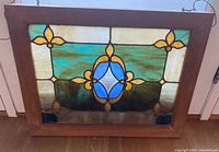 Full view of stained glass panel showing design, colours and wood frame