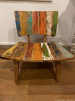 Front view of chair showing colourful plank back and seat with wood legs