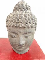 Front view of grey clay Buddha head statue