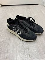 Lateral view of both sneakers showing upper, laces, midsole, graphic text