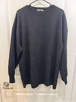 Front view of black Mango XXL sweater on hanger