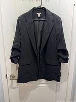 Front view of black H&M blazer on hanger