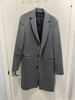 Front view of grey Zara Man coat hanging on door